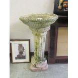 A composite stone fluted bird bath on fluted column