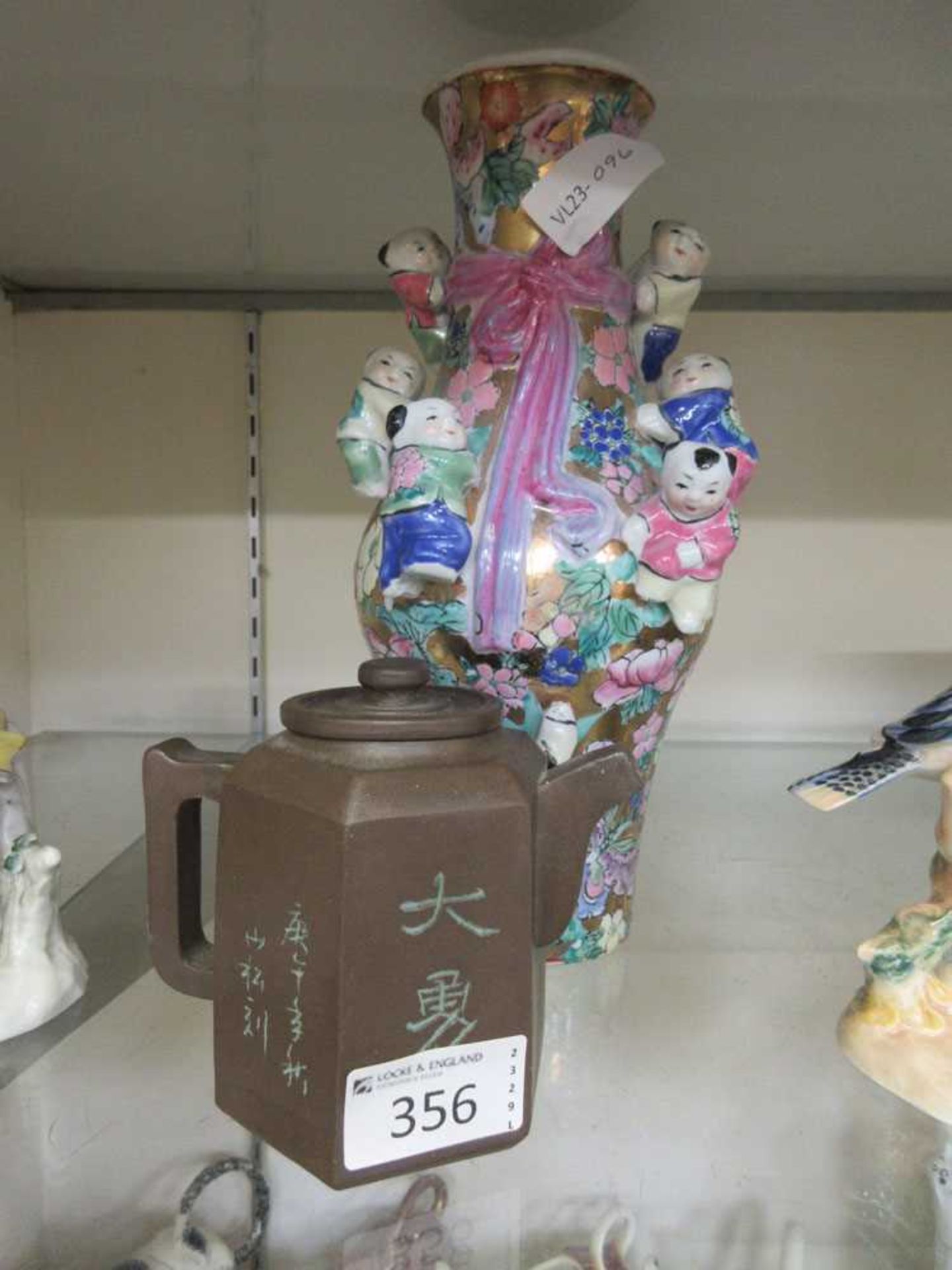 A Chinese floral decorated vase with applied children and six character mark along with a Chinese