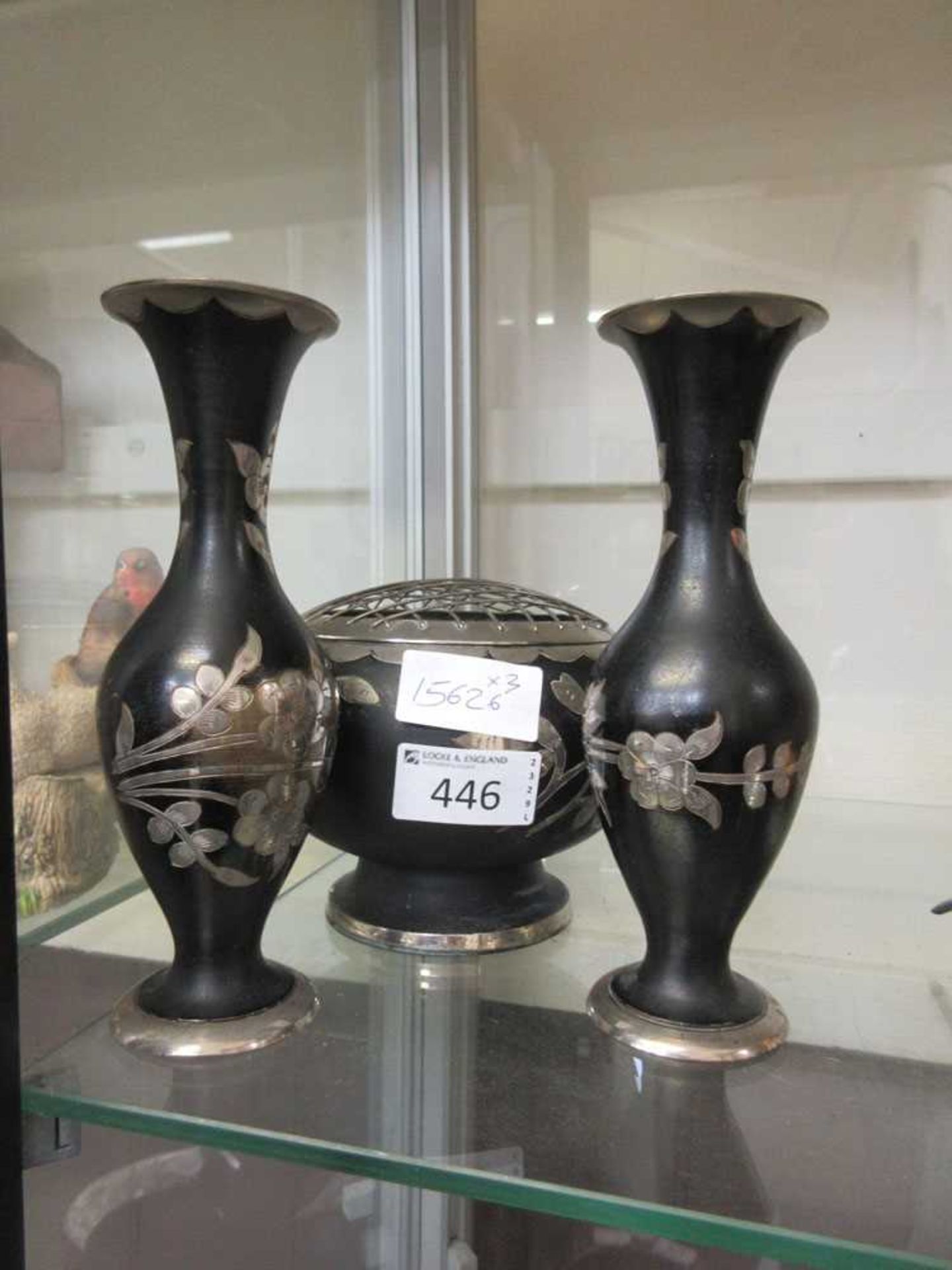 Two Indian white metal and black bud vases along with a matching rose bowl