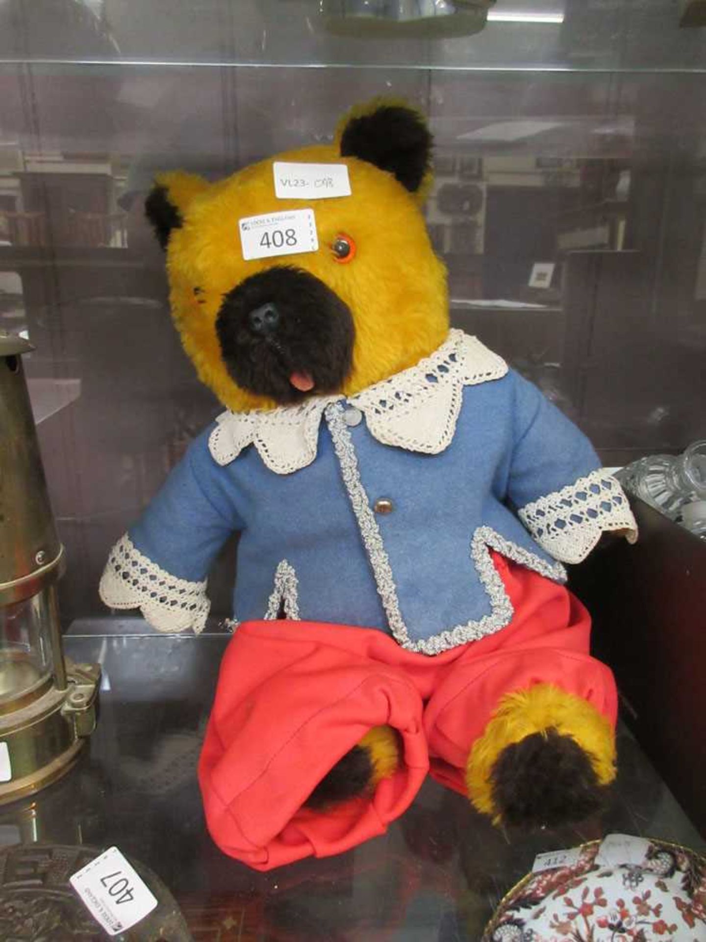 A teddy bear dressed in a blue jacket