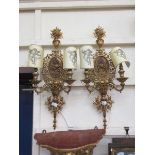 A pair of brass and embossed plaque ornate wall lights