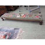 An early 19th century rosewood footstool with floral needlework upholstery Metal brackets have