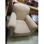 An early 20th century armchair upholstered in a patterned beige fabric