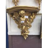 An early 20th century giltwood wall bracket with cupid design