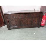 A late 17th century walnut coffer the top over a carved front with three panels