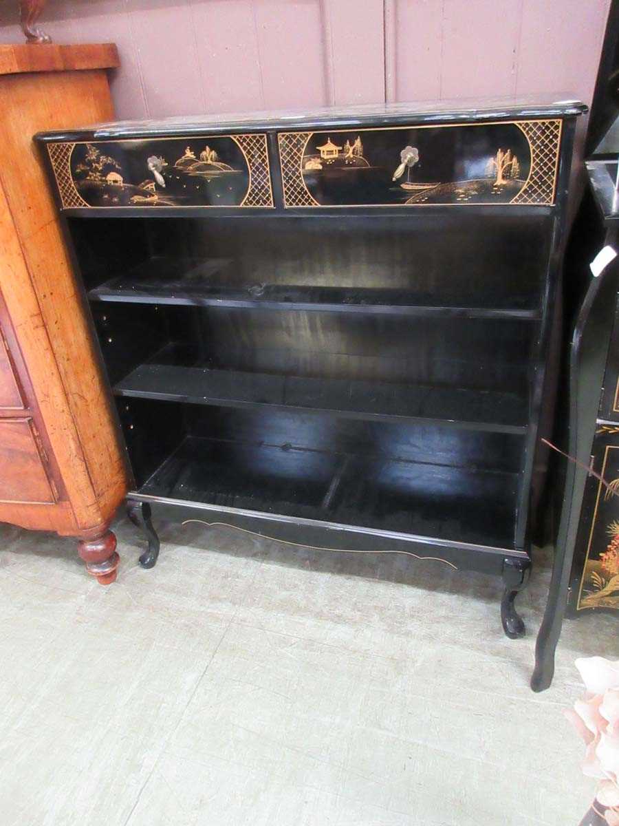 A chinoiserie black lacquered open bookcase with two drawers to top