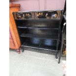 A chinoiserie black lacquered open bookcase with two drawers to top