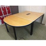 A modern sycamore effect boardroom table on black metal base
