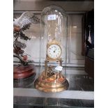 A brass anniversary clock under a glass dome