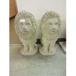 A pair of reconstituted stone garden ornaments in the form of lions Height 50cm