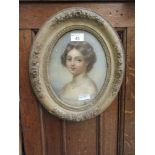 An oval framed and glazed picture of a young lady