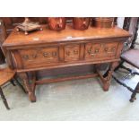 A reproduction oak side table with three drawers on barley twist supports