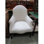 A bedroom easy chair in cream damask with similar stool