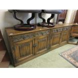 A pair of Old Charm oak cabinets with two drawers over linen fold cupboard doors