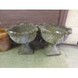 A pair of composite stone garden pots with floral design