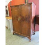 An early 20th century walnut veneered two door cabinet