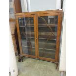 An early 20th century walnut veneered display cabinet