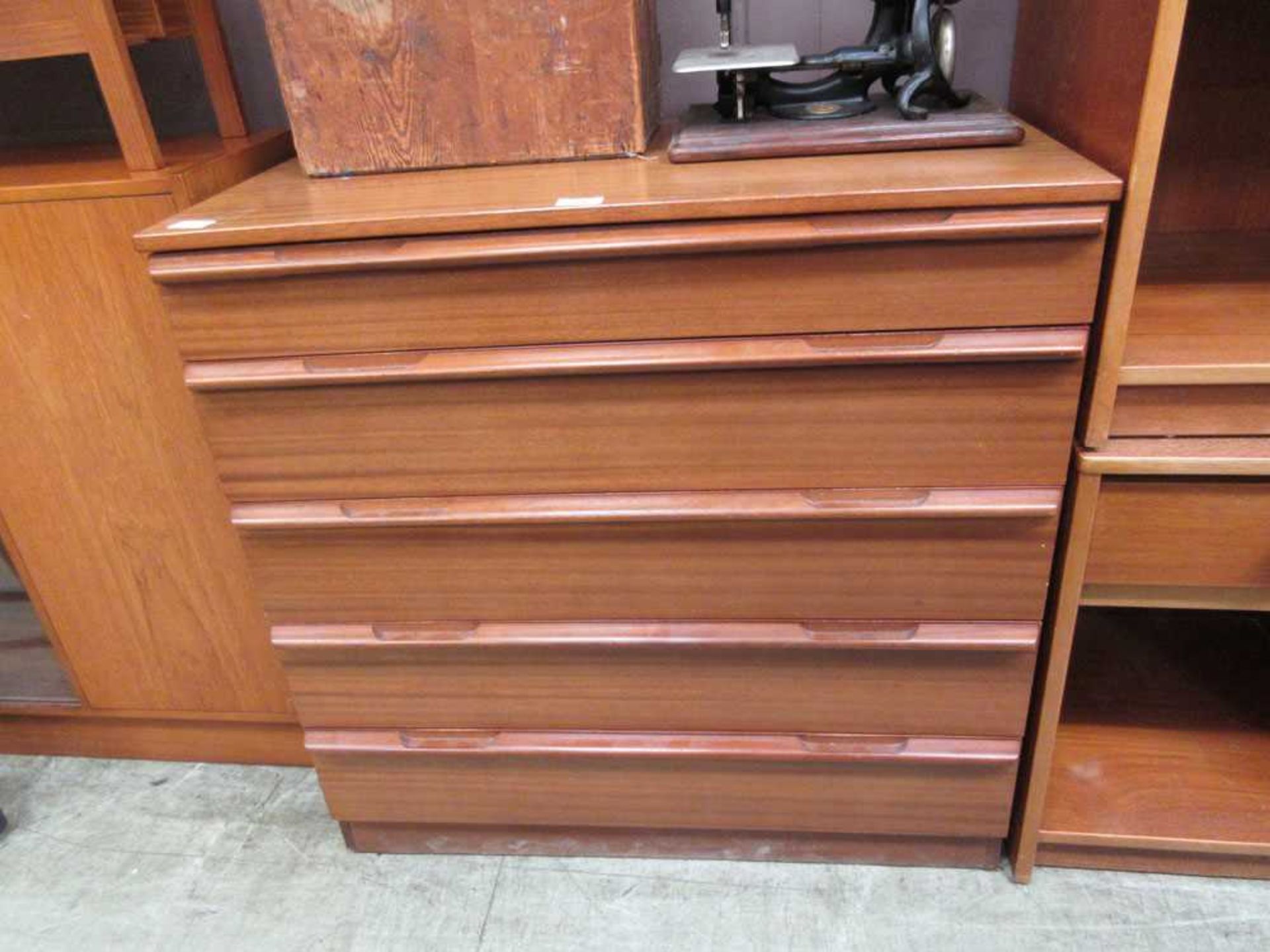 A mid-20th century teak chest of five drawers