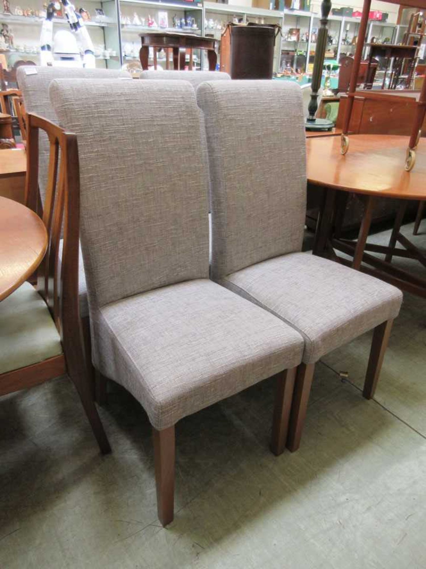 A set of four modern dining chairs upholstered in a grey fabric