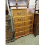 A yew veneered serpentine chest of five drawers