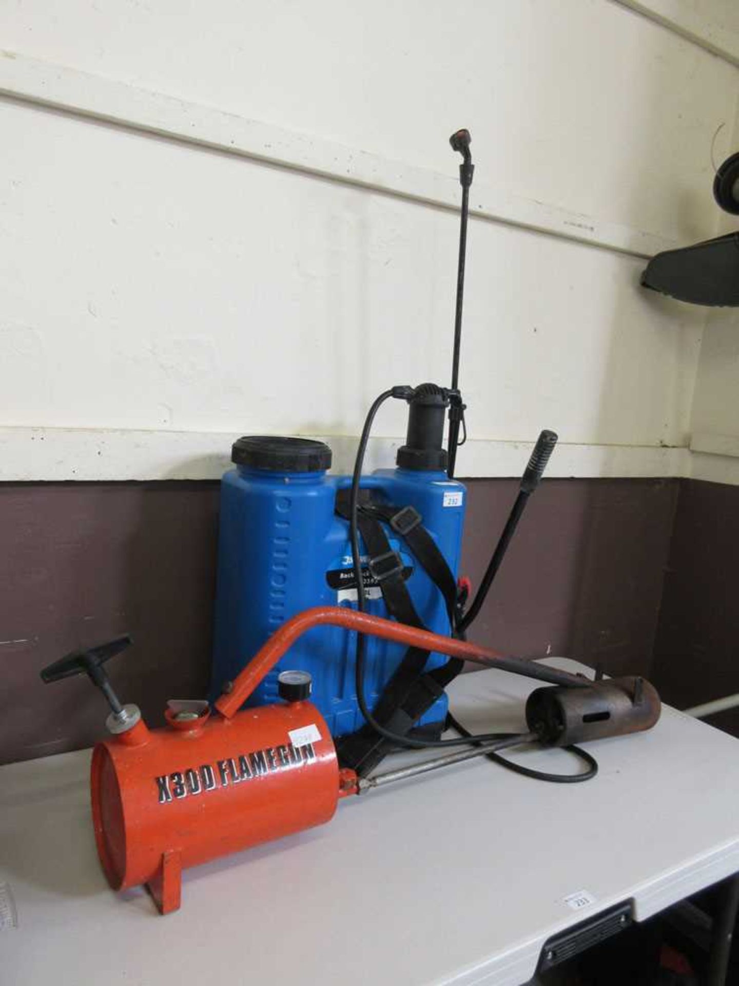 A Silverline back pack sprayer along with a flame gun