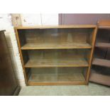 A mid-20th century oak bookcase with glazed sliding doors