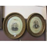 A pair of ornate gilt framed oval photographs of man and woman