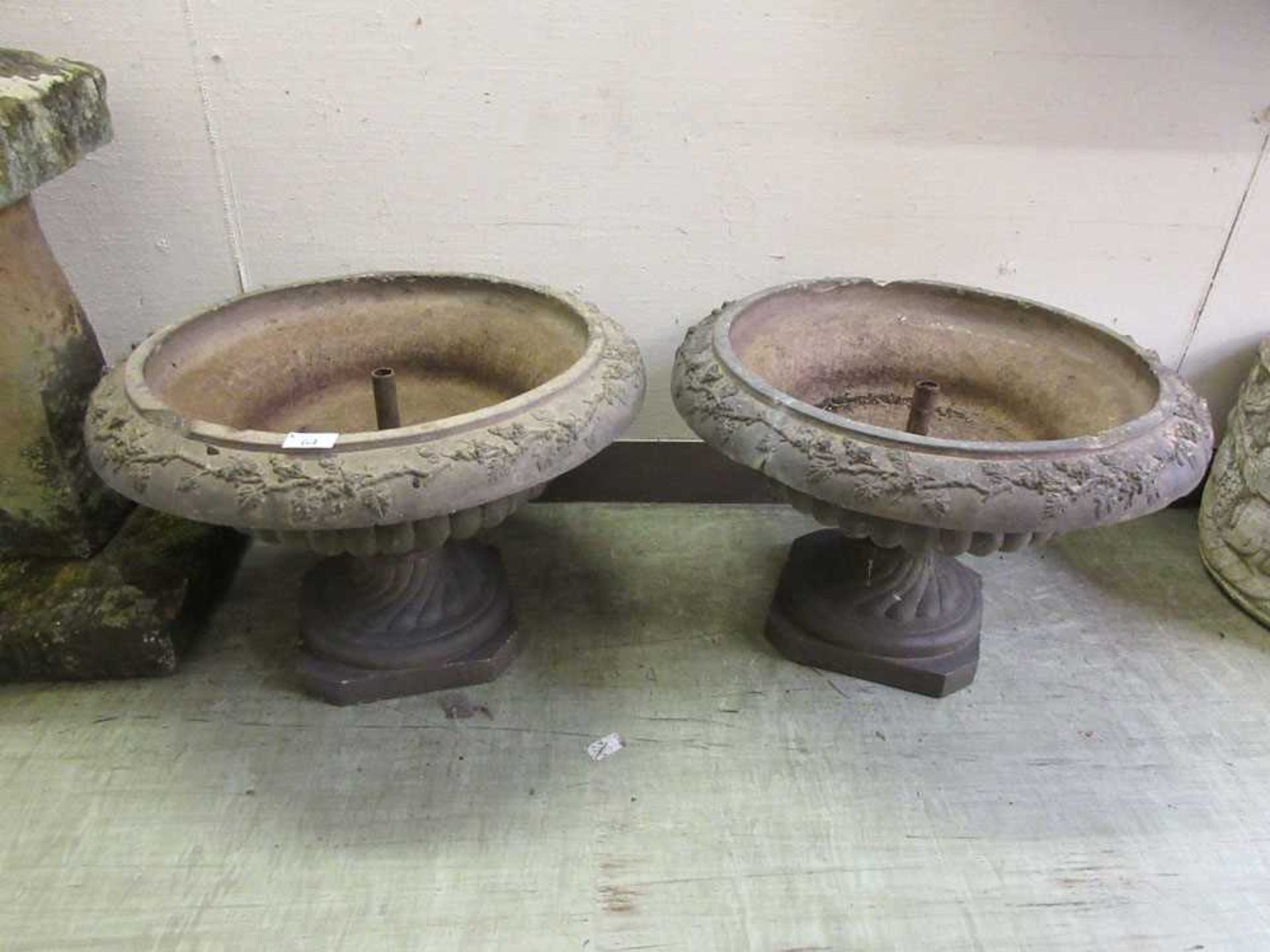 A pair of earthen ware pots with fruiting vine decoration to rim