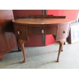 An early 20th century veneered demi-lune desk