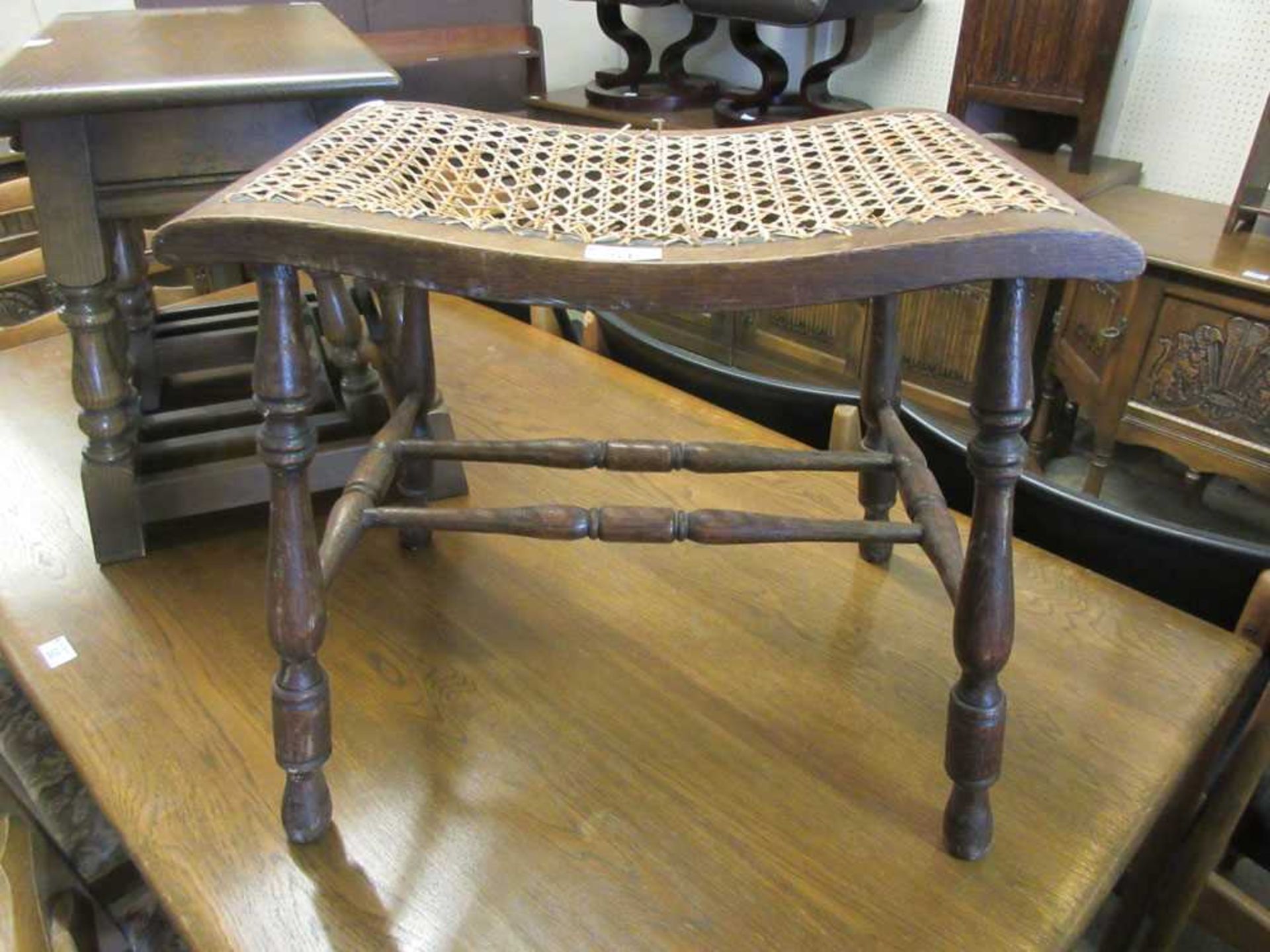 An early 20th century stool with cane seat