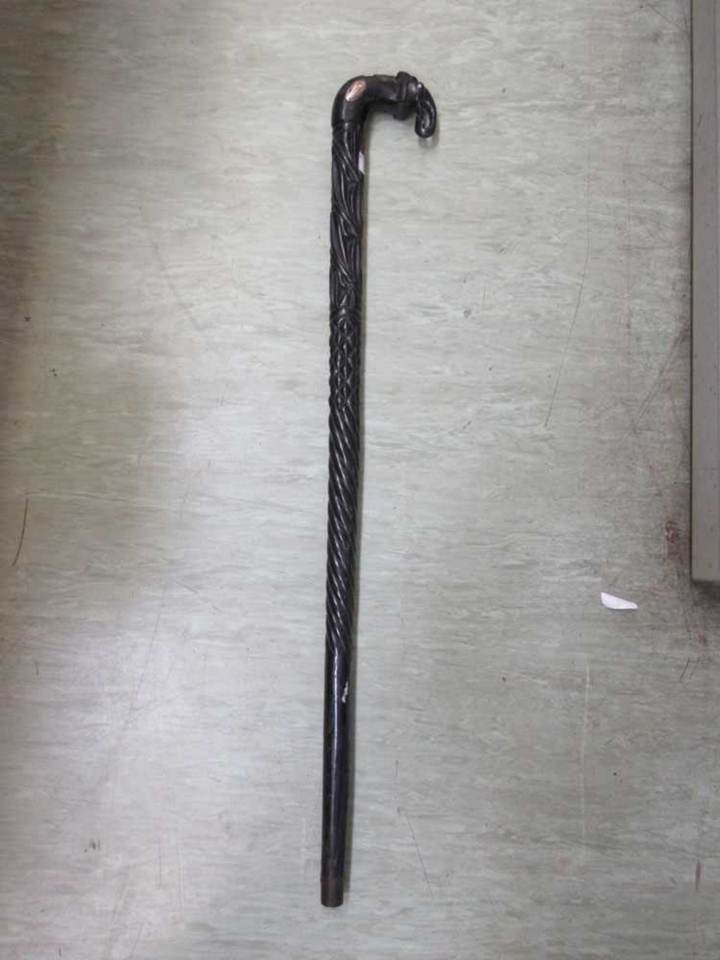 A carved ebony walking stick with elephant design handle Length: 95cm.