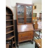 An early 20th century bureau bookcase, the top with leaded glazed door over fall front with fitted