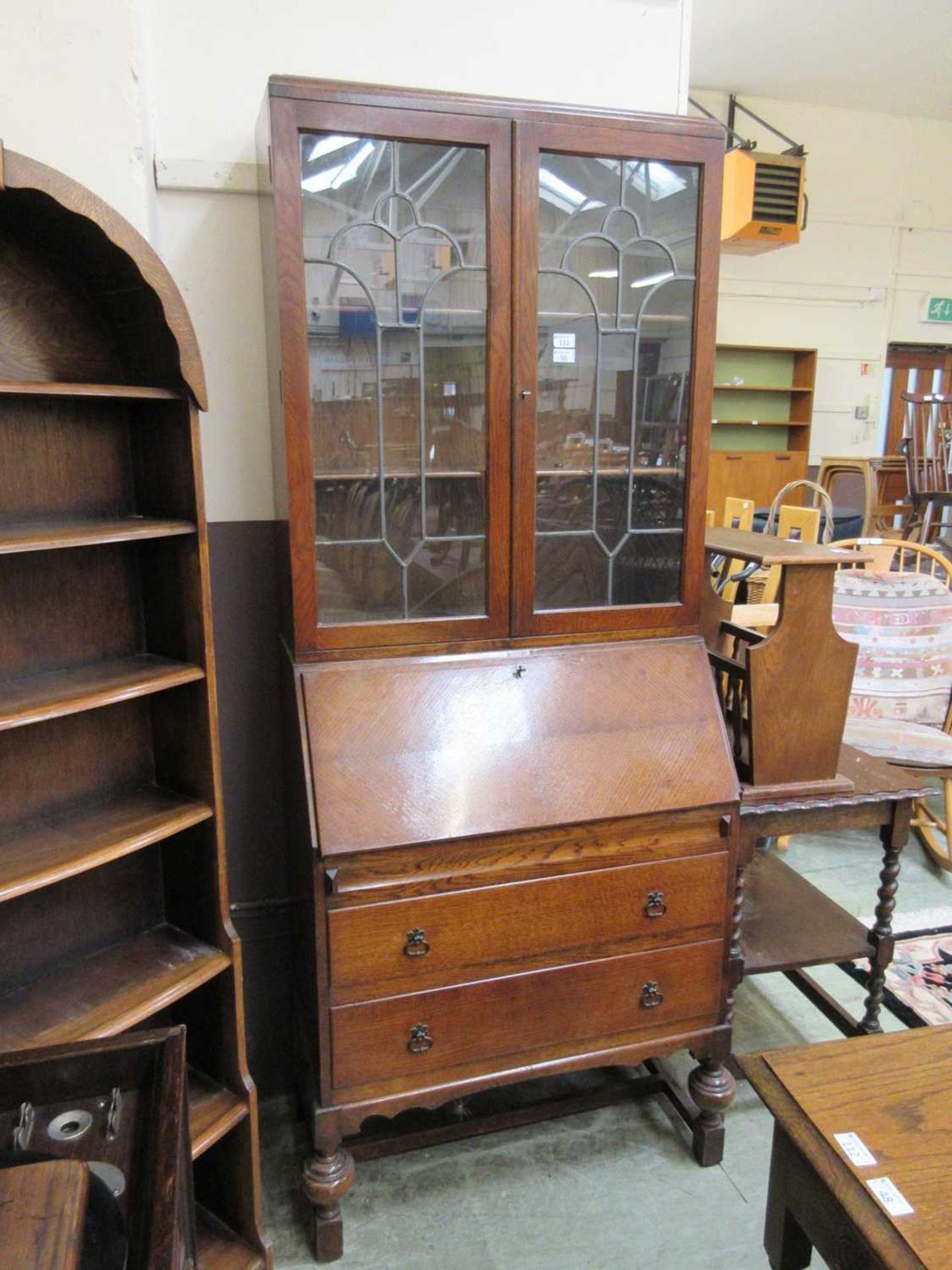 An early 20th century bureau bookcase, the top with leaded glazed door over fall front with fitted