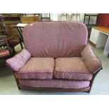 A modern Ercol two seat settee upholstered in an oak patterned red fabric