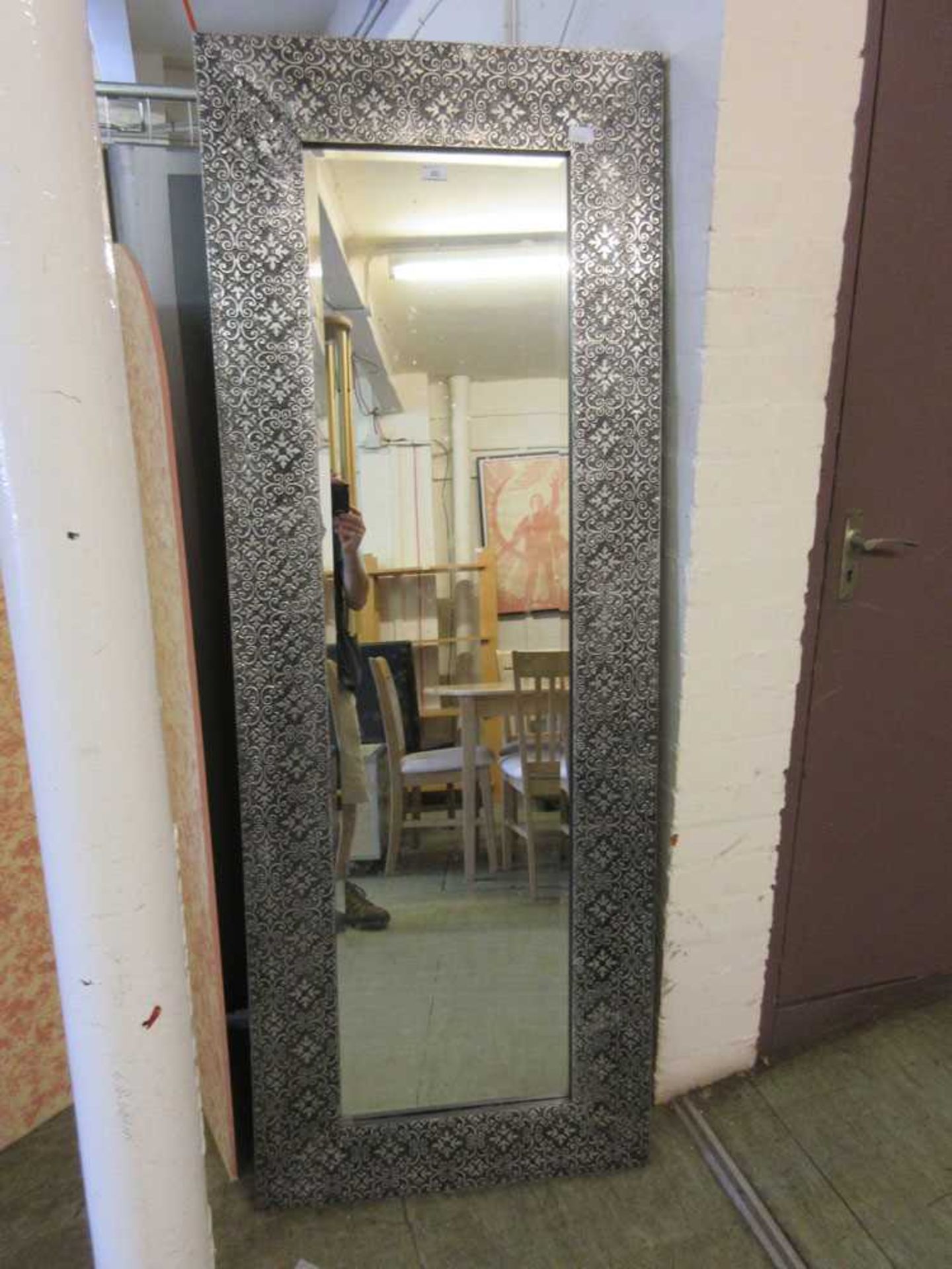 A modern embossed silver framed floor standing mirror