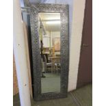 A modern embossed silver framed floor standing mirror