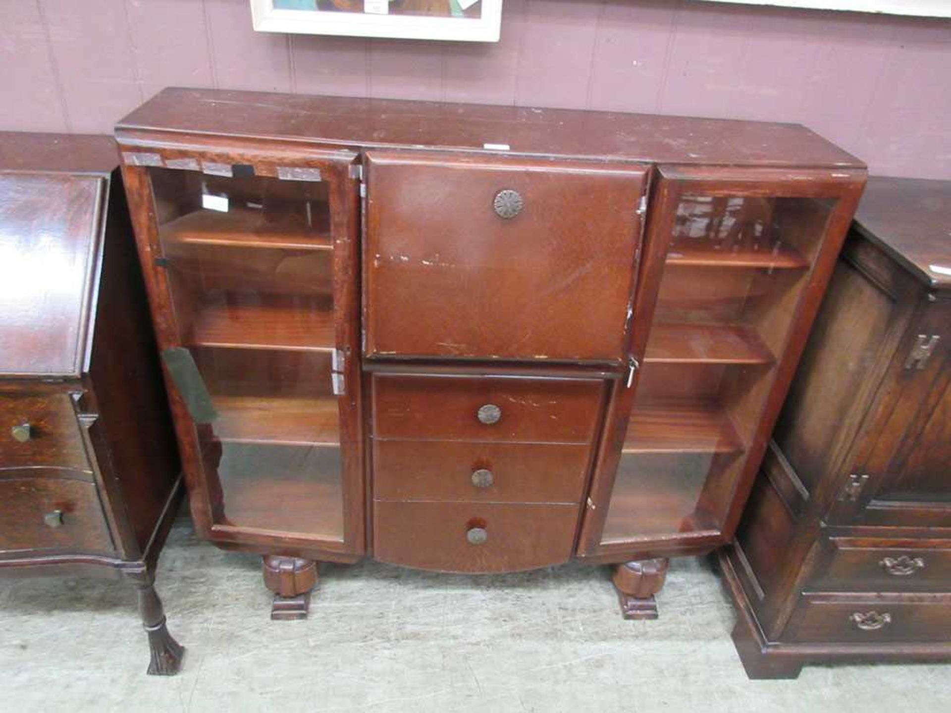 An early 20th century display cabinet with central bureau section