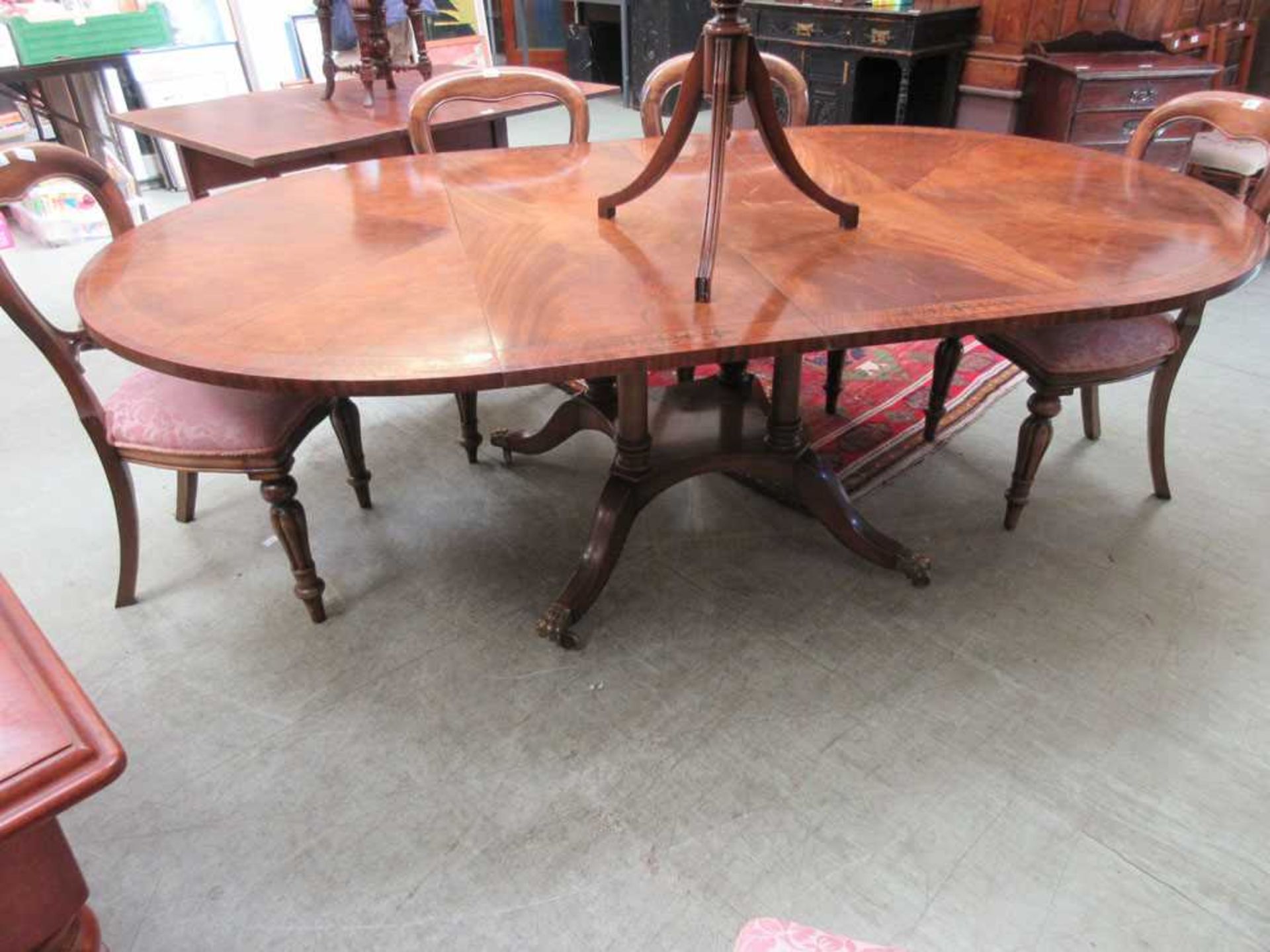 A modern Regency style mahogany and brass inlaid extending dining table with two extra leaves on