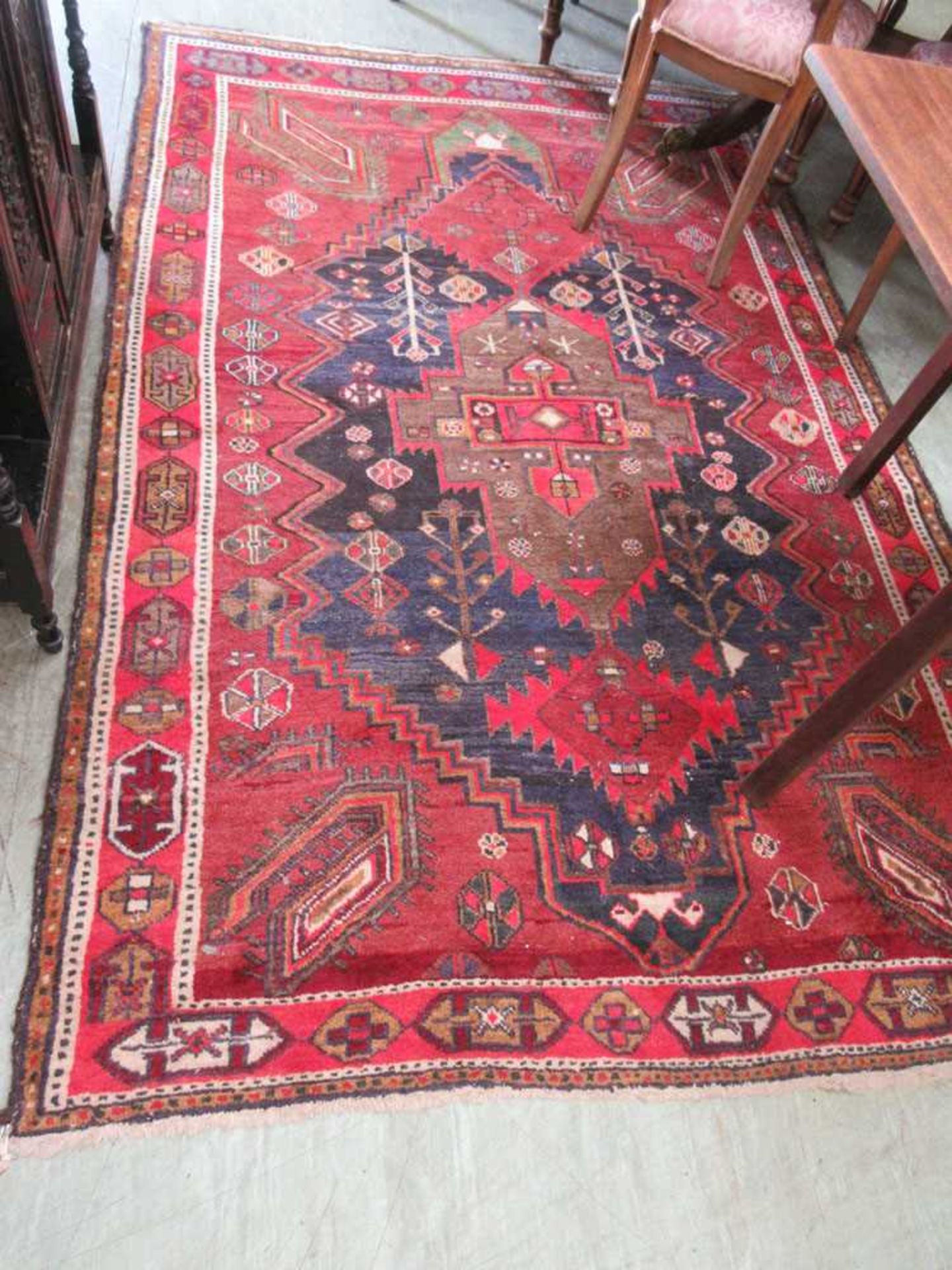 A handwoven Persian style red ground rug