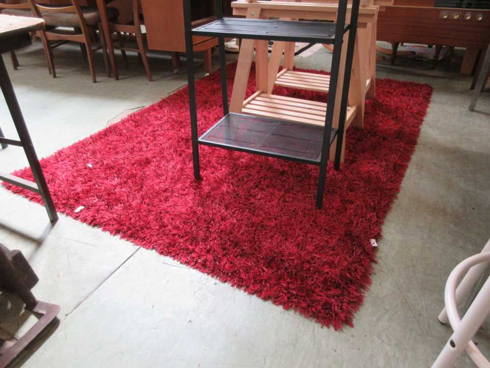 A red ground rug with heavy shag pile