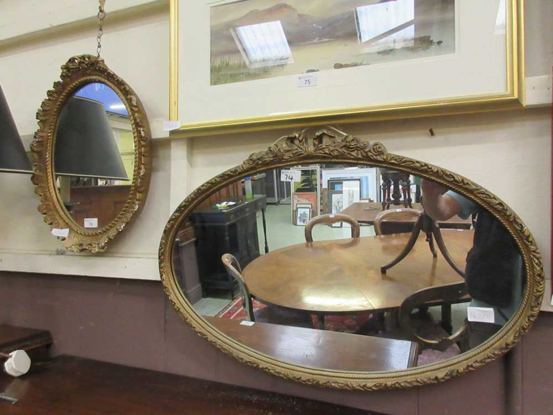 Two ornate gilt framed oval mirrors