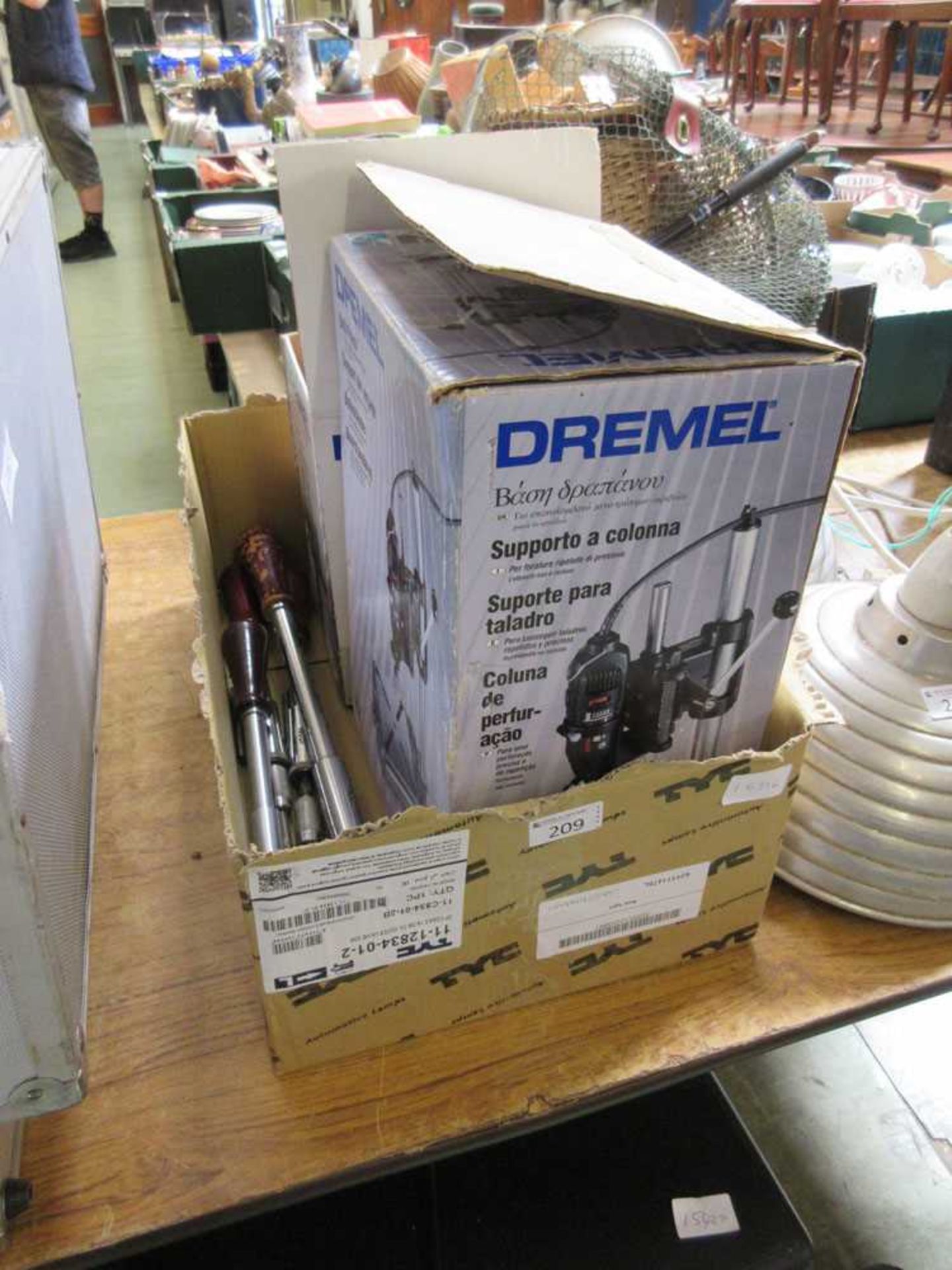 A boxed Dremel multitool on stand along with other hand tools