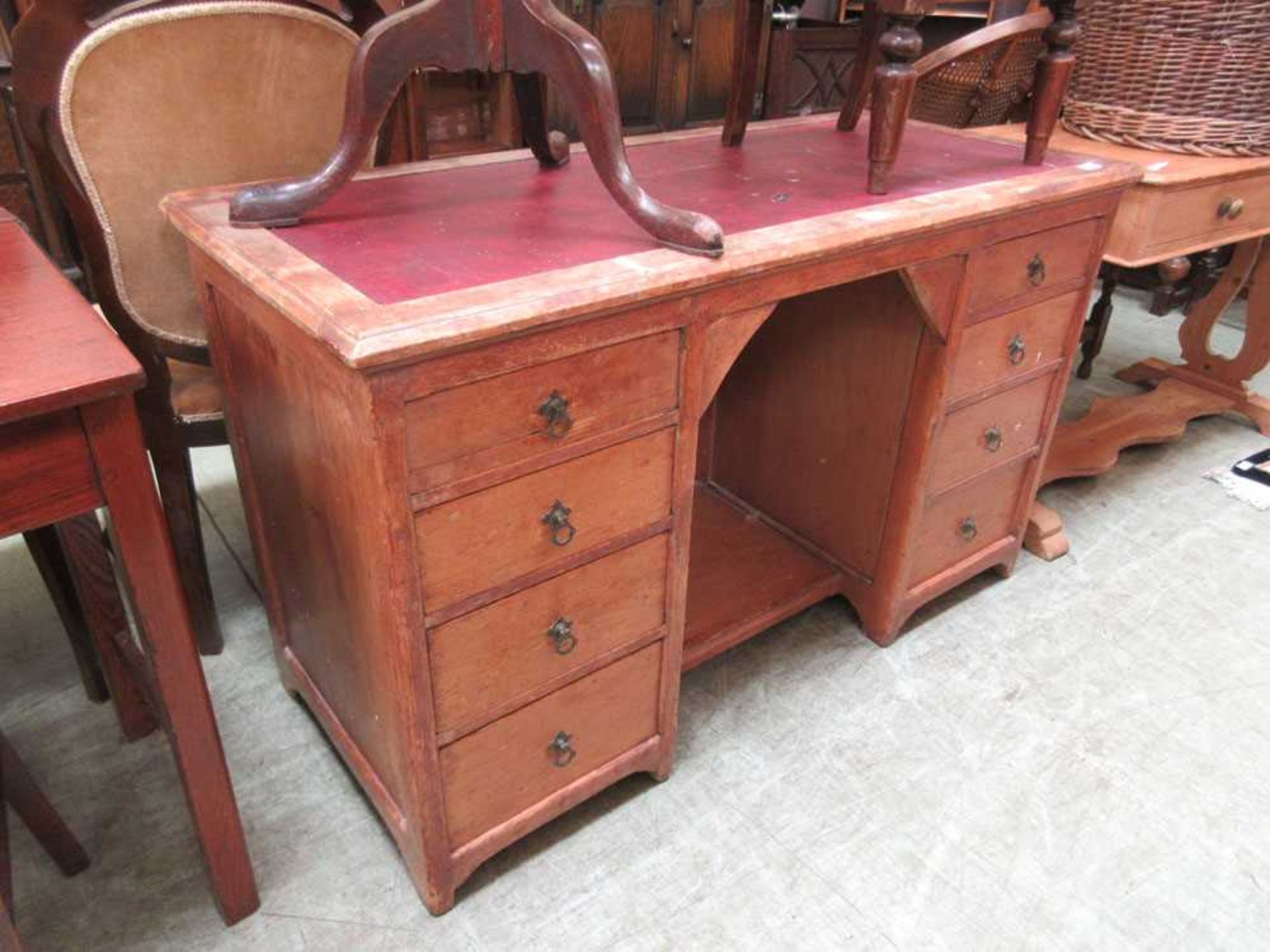 A late 19th century pine kneehole desk with red leatherette insert to top