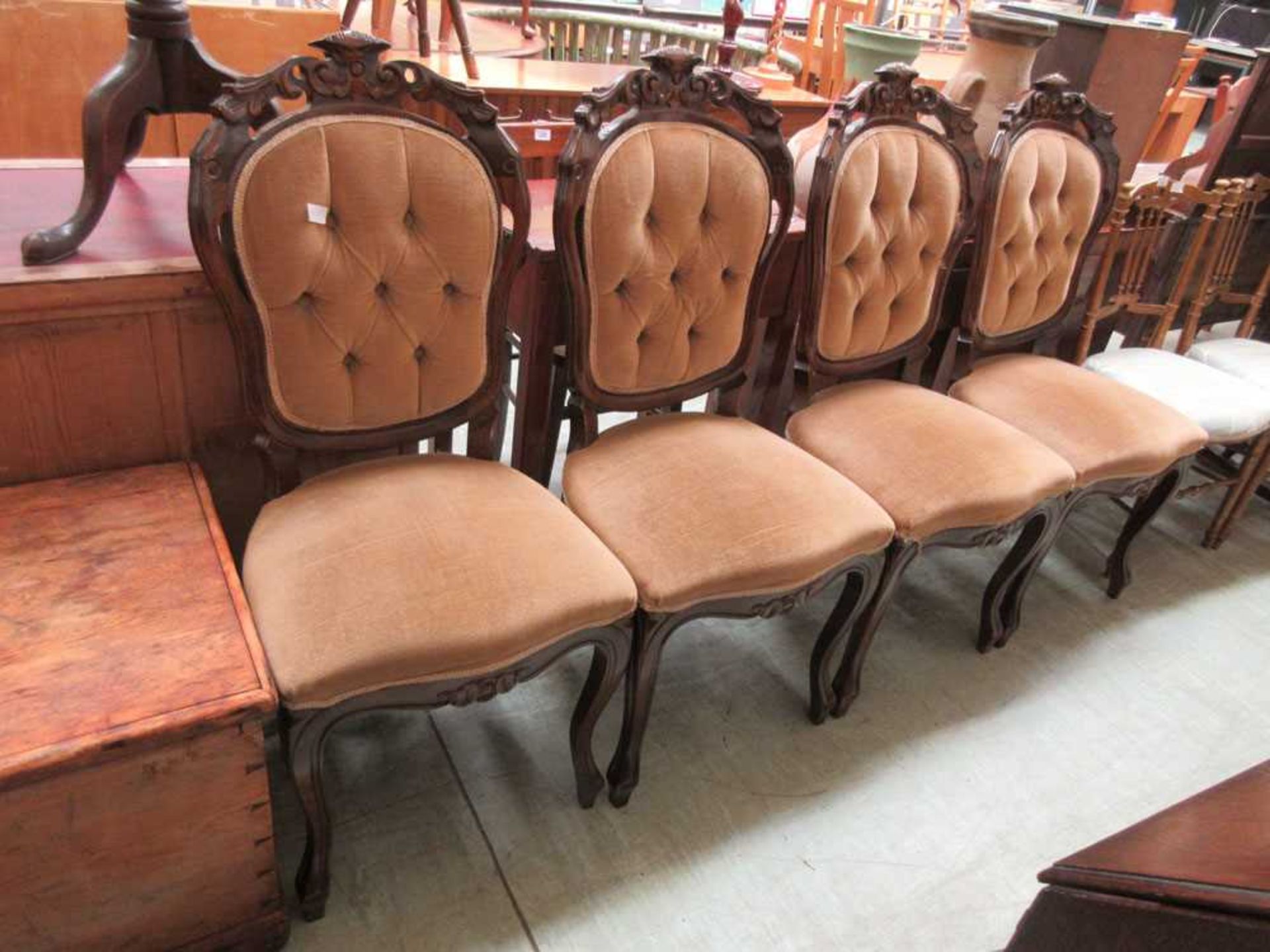 A set of four stained beech 19th century style dining chairs upholstered in a beige button back