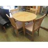 A modern beech effect kitchen table along with a set of four matching chairs