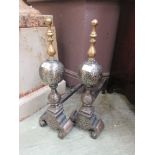 A pair of cast iron and brass fire dogs