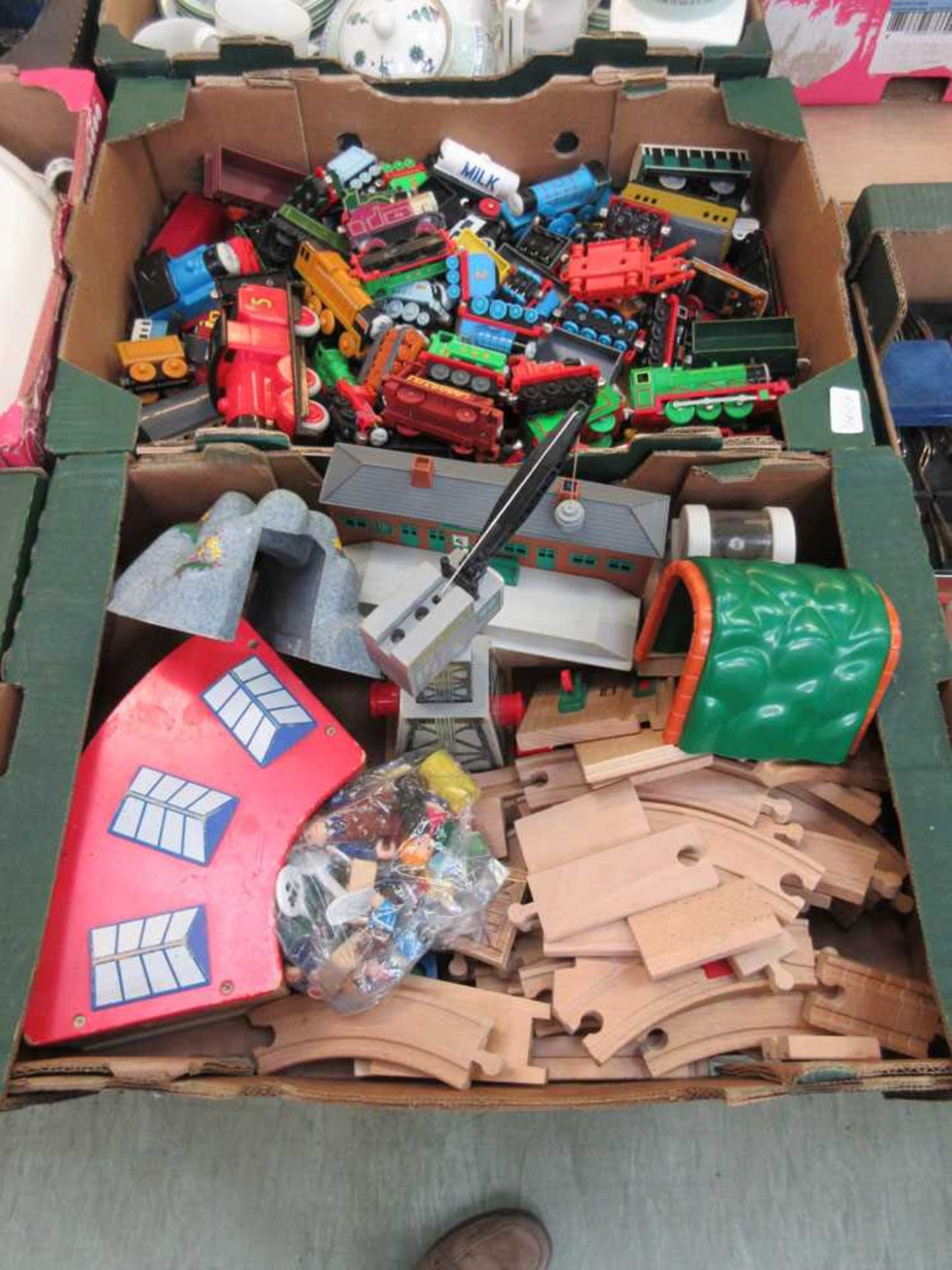 Two trays containing a wooden train set and many Thomas The Tank Engine items