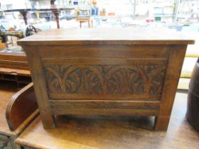 A 20th century oak coffer with carved panel to front