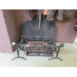A cast iron fire back along with wrought iron fire grate and dogs