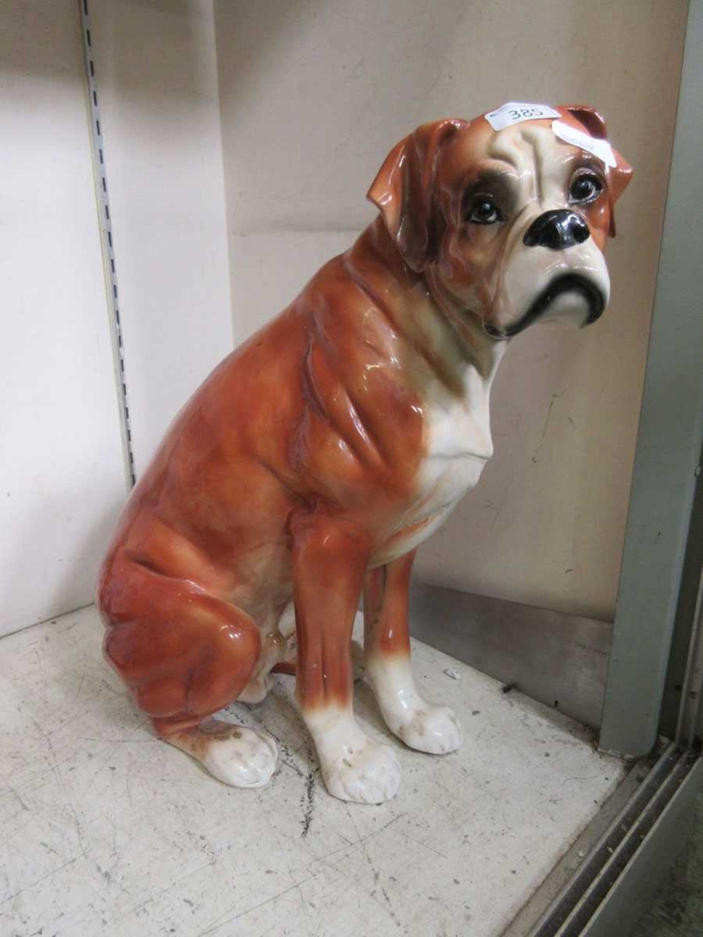 A ceramic model of a seated boxer dog
